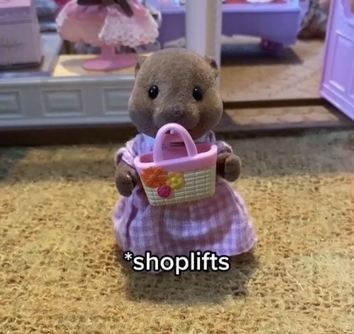 calico critter holding little bag with the caption shoplifting